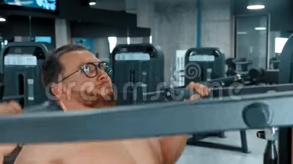 一个长着胡子有魅力的健美男子在健身房做力量锻炼视频的预览图
