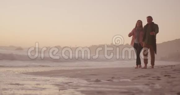 活跃的高级夫妇在海滩上散步视频的预览图