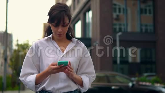 在城里使用智能手机行走的白人女性视频的预览图