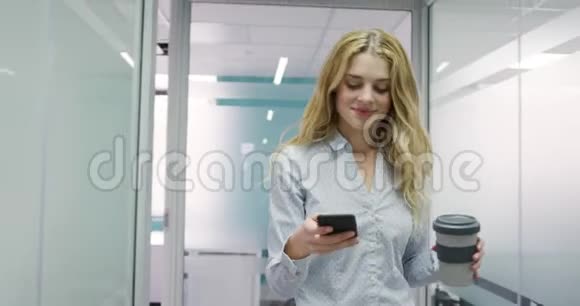女人手里拿着电话和咖啡视频的预览图