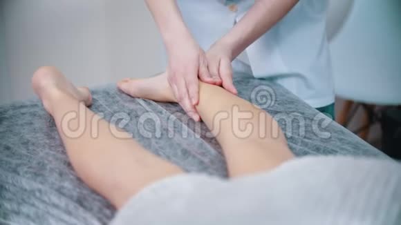按摩按摩治疗师正在揉一个年轻女人的腿视频的预览图