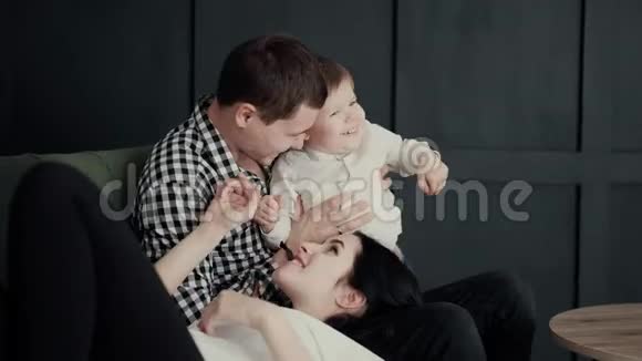 友好无忧无虑的家庭一个孕妇躺在丈夫的大腿上长子在他们旁边玩耍视频的预览图