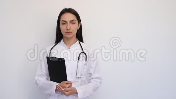 友好的女医生微笑着手里拿着一个文件夹脖子上有一个听诊器视频的预览图
