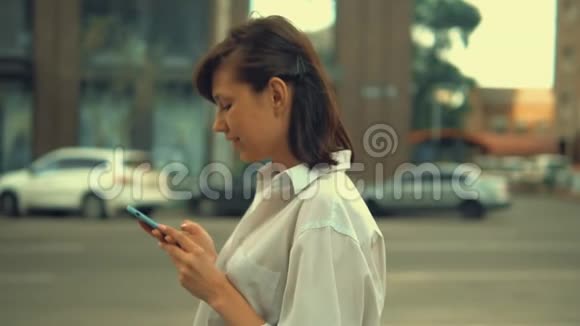 城市中使用移动行走的成年妇女视频的预览图