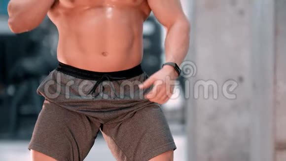 一个赤膊男子健美运动员站在健身房视频的预览图