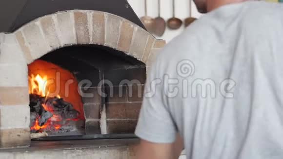 做真正的意大利披萨用比萨饼皮把比萨饼放在木火比萨饼烤箱里视频的预览图