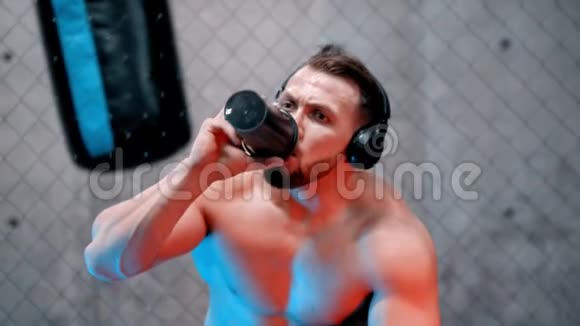 一个漂亮的拳击手在健身房里喝水霓虹灯视频的预览图