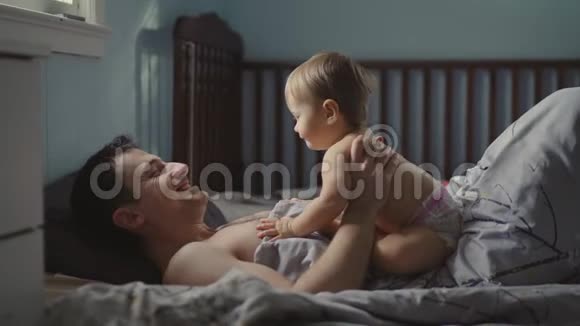 英俊的年轻爸爸正在和他可爱的小女孩玩耍微笑着视频的预览图
