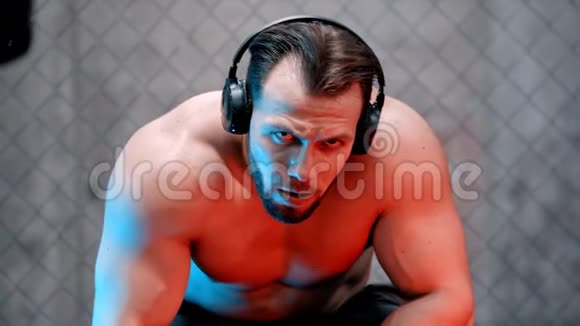 戴着耳机的拳击手坐在长凳上看着摄像机视频的预览图