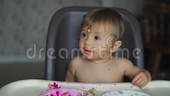坐在白色高椅上吃水果和蔬菜的女婴视频的预览图