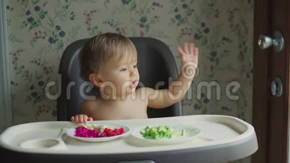 坐在白色高椅上吃水果和蔬菜的女婴视频的预览图