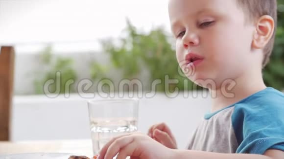 可爱健康的学龄前小男孩坐在儿童咖啡馆里吃意大利披萨快乐的孩子急切地吃视频的预览图