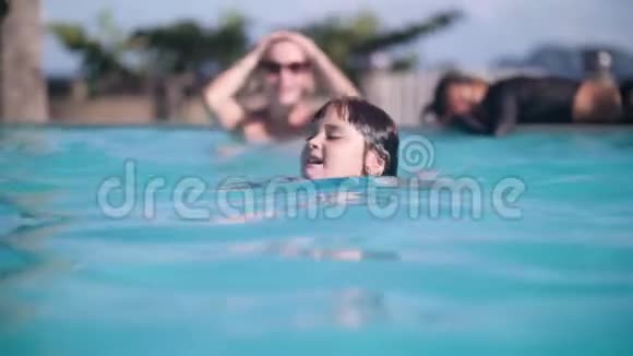 快乐女孩子的肖像在热带酒店的游泳池游泳前景视频的预览图
