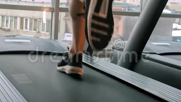 一个穿运动鞋的人在健身房的跑步机上跑步视频的预览图