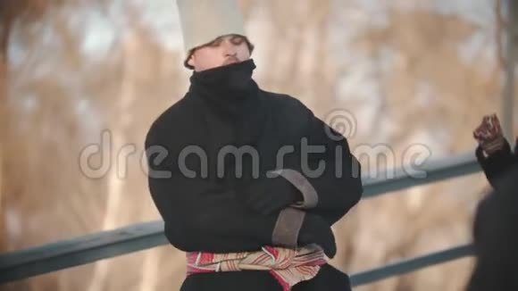 俄罗斯民间传说穿着羊皮大衣的男人在公园里寒冷的日子跳舞视频的预览图