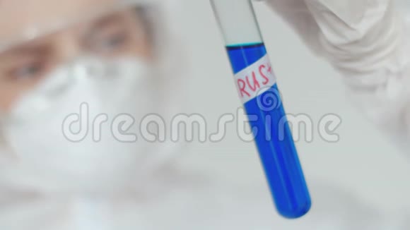 一位女医学教授用蓝色溶液检查带有病毒阳性测试标签的试管一个女人视频的预览图