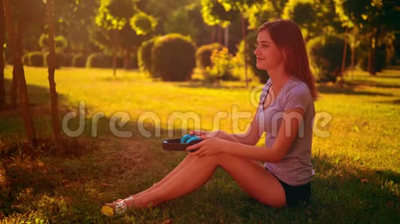快乐的女性坐在绿草上视频的预览图
