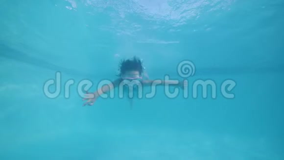 戴着游泳面具的小女孩在游泳池水下潜水看着相机视频的预览图