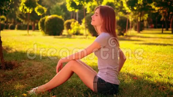坐在草坪上微笑的女性视频的预览图