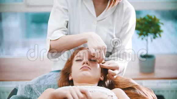 按摩按摩治疗师正在捏一个女人的脸视频的预览图