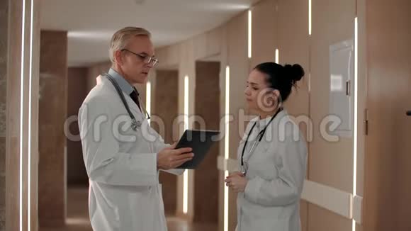 两位治疗师在医院走廊讨论患者的诊断视频的预览图