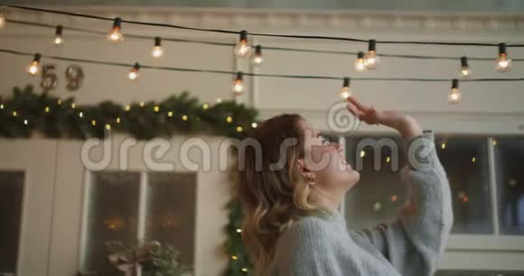 穿着暖和毛衣的女人头上戴着轻盈的花环为圣诞节装饰着斯堪的纳维亚半岛舒适的新生活视频的预览图