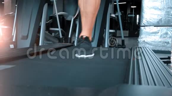 一个穿着运动鞋的男人在现代体育健身馆的跑步机上跑步视频的预览图