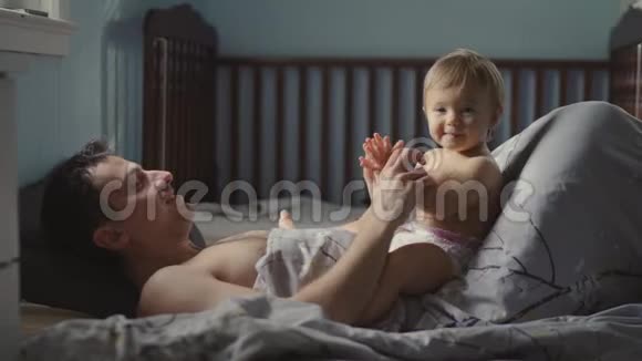 英俊的年轻爸爸正在和他可爱的小女孩玩耍微笑着视频的预览图