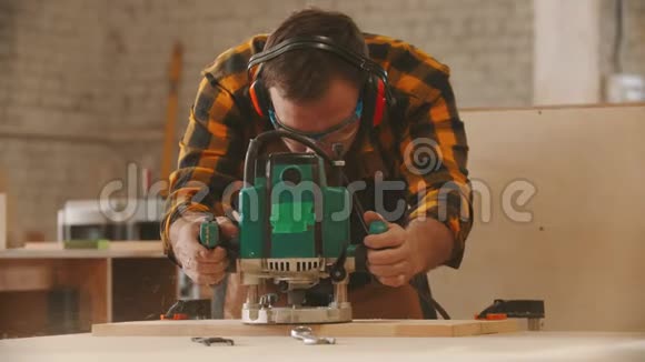 木工行业戴防护眼镜和戴耳机打磨木制物品的工人视频的预览图