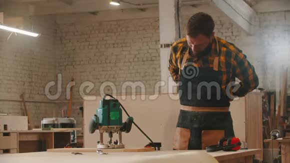 木工行业的工人穿上围裙开始使用磨床视频的预览图