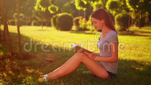 开朗的女性读小说坐在绿草上视频的预览图