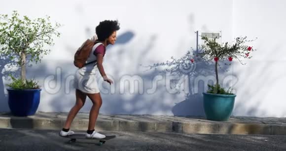 街头滑滑板的混血女人视频的预览图