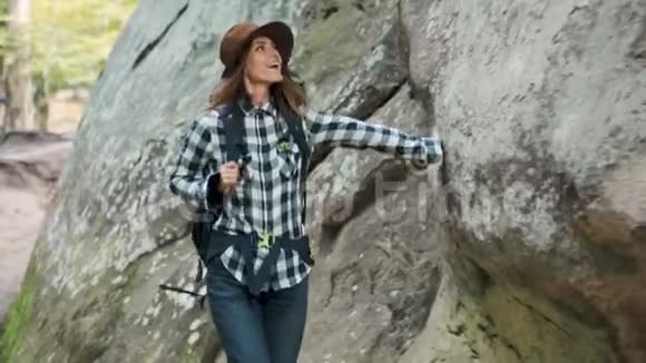 女人走在岩石旁边视频的预览图