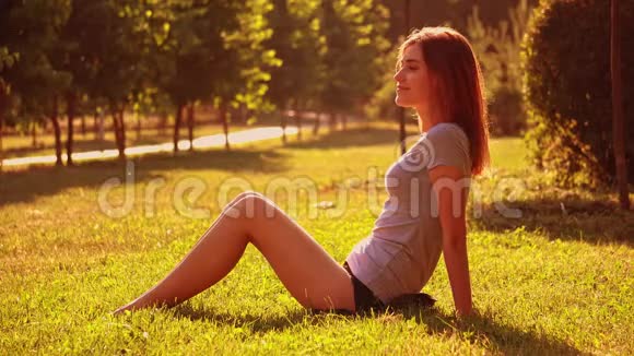 微笑的女性坐在草坪上放松视频的预览图