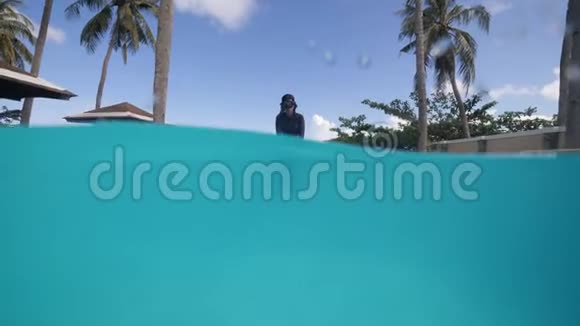 迷人的亚洲女孩在浮潜面具潜水在游泳池和水下游泳视频的预览图