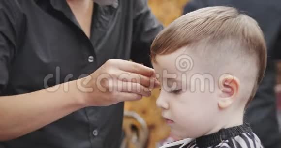 当冠状病毒流行时孩子们在沙龙理发小男孩理发孩子们头发视频的预览图