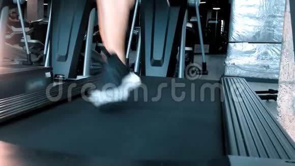 一个穿着运动鞋的男人在运动健身房的跑步机上跑步视频的预览图
