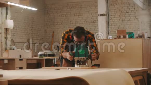 木工行业戴防护眼镜和戴耳机切割木制物品的工人视频的预览图