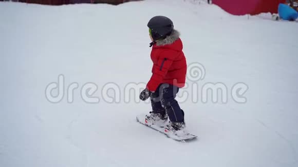 年轻人滑雪板教练教小男孩如何骑滑雪板冬季活动概念慢镜头视频的预览图
