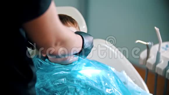 一个正在做牙齿的小男孩戴上安全罩和眼镜视频的预览图