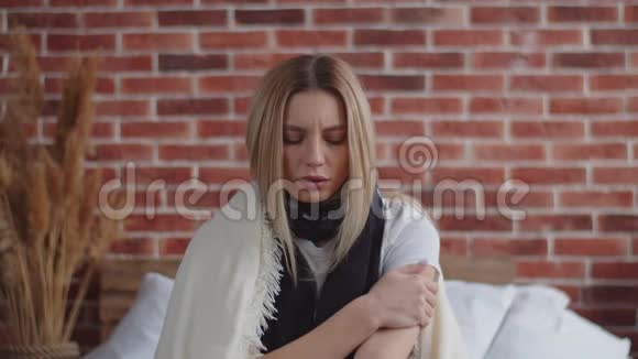 那个冻僵的女孩用手揉着肩膀用毯子盖住自己在温暖自己的同时揉搓它视频的预览图