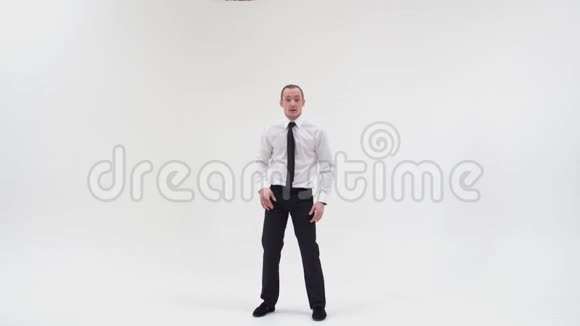 一个穿着裤子和衬衫的人正在用他的脚跳舞把他的腿分开一只手握着视频的预览图