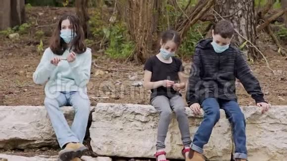 冠状病毒大流行孩子们戴着口罩避免传染坐着无聊视频的预览图