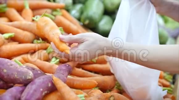 漂亮的年轻漂亮的女孩或女人在市场上买食物在市场上摘胡萝卜卷心菜生菜花椰菜视频的预览图
