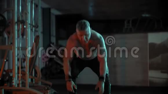 一位成年强壮的健美运动员在体育馆里与绳索搏斗视频的预览图