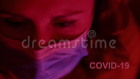 悲伤的女人用红灯往下看戴着外科口罩COVID19关闭视频的预览图