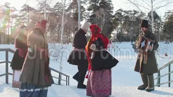 俄罗斯民间穿着传统俄罗斯服装的男女正在公园里手风琴跳舞视频的预览图