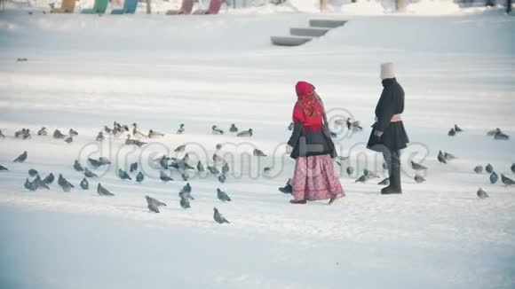 俄罗斯的传统人们穿着漂亮的衣服在冰冻的池塘里追逐鸽子视频的预览图