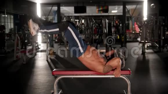 一位成年男子健美运动员躺在长凳上锻炼背部视频的预览图