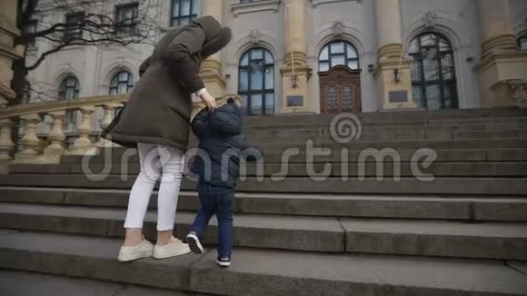 小男孩在国家艺术博物馆的楼梯上妈妈牵着他的手慢动作视频的预览图